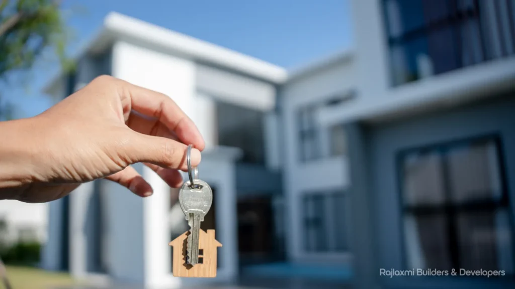 Happy homebuyer holding a house key in front of a modern flat in MIHAN Nagpur.